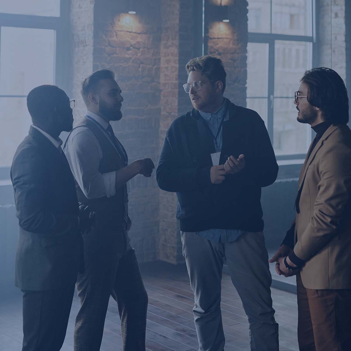 Group of people standing and talking in office setting